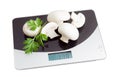 Several champignon mushroom on digital kitchen scale Royalty Free Stock Photo
