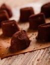 Several chocolate truffles on wooden board