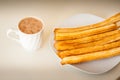 Several churros on small plate and milk with chocolate