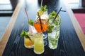 Several cocktails drinks on wooden table at bar in summer time. Summer seasonal alcohol drinks in a bar or restaurant.