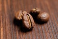 Several coffee beans on a wooden burnt background. Macro Royalty Free Stock Photo