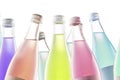 Several colored colorful bottles with carbonated drinks and lemonade on a white background isolate