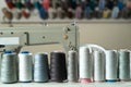 Several colored spools of thread for sewing and embroidery on a white wooden table Royalty Free Stock Photo