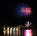 several colorful fireworks exploding in the dark night sky creating amazing light and color effects above the buildings of the