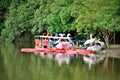 Several colorful pedal boats parked by the lake