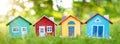 Several colourful houses models standing on the green grass.