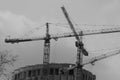 Several construction cranes with arrows that complete the round house. Royalty Free Stock Photo