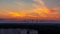 Several construction cranes on the background of colorful sunset sky