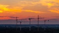 Several construction cranes on the background of colorful sunset sky