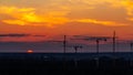 Several construction cranes on the background of colorful sunset sky