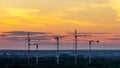 Several construction cranes on the background of colorful sunset sky