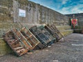 Several crab pots against the stone wall of Craster Harbour in Northumberland, England, UK Royalty Free Stock Photo