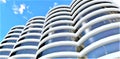 Several cylindrical skyscrapers combined into a single architectural composition. Bottom view against a blue sky. 3d rendering