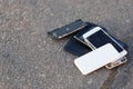 Several broken smartphones are on the asphalt. Royalty Free Stock Photo