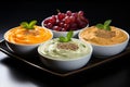 Several different sauces for dishes, served on small plates. Hummus