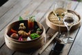 Several different traditional Chinese dimsum dumplings in a wooden basket cooked for guests on a wooden table in a