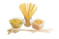 Several different uncooked pasta and a bunch of wheat ears