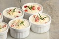 Several dishes with casserole - sour cream, tomatoes and fish or other ingredients before baking