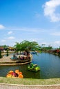 several duck boats, crossing an artificial lake