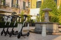 Several electric scooters for rent by tourists and citizens stand in rows on the sidewalk of the old city Royalty Free Stock Photo