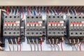 Several electrical contactor on a mounting panel in electrical closet.