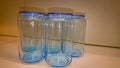 Several empty blue glass jars stand on a shelf