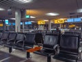 several empty chairs line the terminal at night, with airport signs in the background Royalty Free Stock Photo