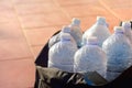 Several empty plastic water bottles are in a black bag, on brown tiles Royalty Free Stock Photo
