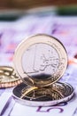 Several 500 euro banknotes and coins are adjacent. Symbolic photo for wealt.Euro coin balancing on stack with background of bankno Royalty Free Stock Photo