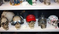 Several fake plastic skulls disguised with cute and funny accessories arranged on a shelf lined up for sale Royalty Free Stock Photo