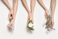 Several female hands hold different flowers. Well-groomed beautiful hands with manicure