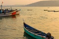 Several fishing boats in the Bay, on the bow of one boat sits stork. Early morning in a fishing village in the North of Goa, India