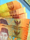 Several five thousand rupiah notes in hand