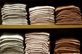 Three plain cotton t-shirts lined up neatly on the shelf. in a rustic interior.