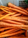 several fresh orange carrots in a white plastic box