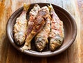 Several fried red mullet fishes on ceramic plate Royalty Free Stock Photo