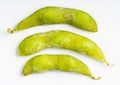 Several frozen Edamame pods close up on gray