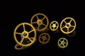 Several gears made of yellow metal on a black