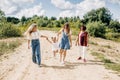 Several generations of women of the same family are walking along a dirt road outside the city, enjoying the time spent