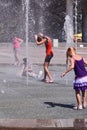 Several girls play in the city fountain