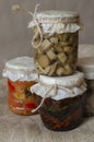 Several glass jars with canned mushrooms and sun-dried tomatoes Royalty Free Stock Photo