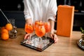 Several glasses of cold bright orange drink on tray stand on the table.