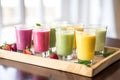 several glasses of freshly made smoothies on a tray