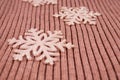Several glitter snowflakes on a flat knitted beige cashmere fabric