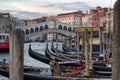 Several gondolas docked at the bay of canal in between wooden stick close the Rialto bridge, famous in Venice city, Italy, Europe Royalty Free Stock Photo