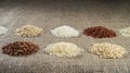 Several heaps of rice of different varieties on the background of sacking. Royalty Free Stock Photo