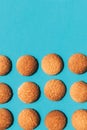 Several homemade cookies placed in rows isolated on a blue background.