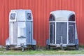 Several horse transportation trailers parked on the grass