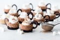 Several hot cocoa mini cheesecakes topped with whip cream and marshmallows.