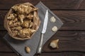 Several Jerusalem artichoke tubers in a paper bag on a wooden table with copy space. Helianthus tuberosus. Top view Royalty Free Stock Photo